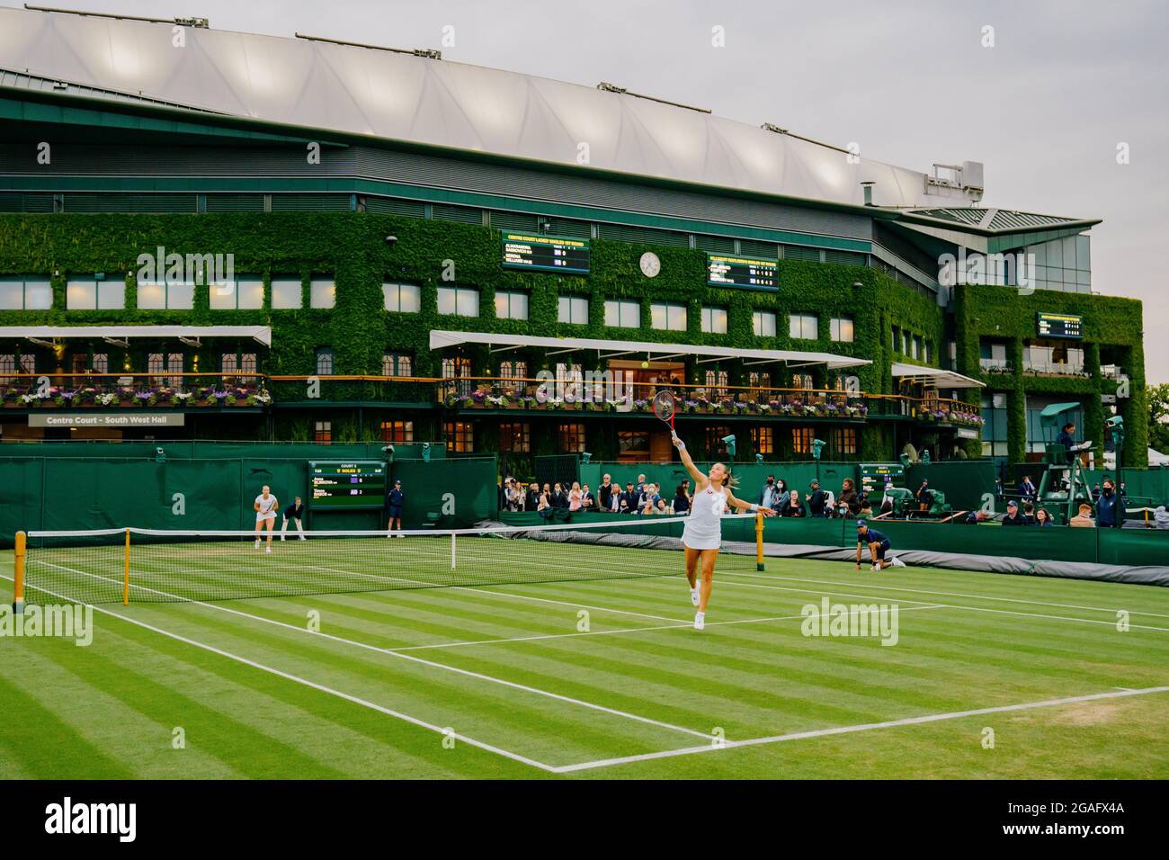 Anna Blinkova of Russia lobs Timea Babos at Wimbledon with view of Centre Court Stock Photo