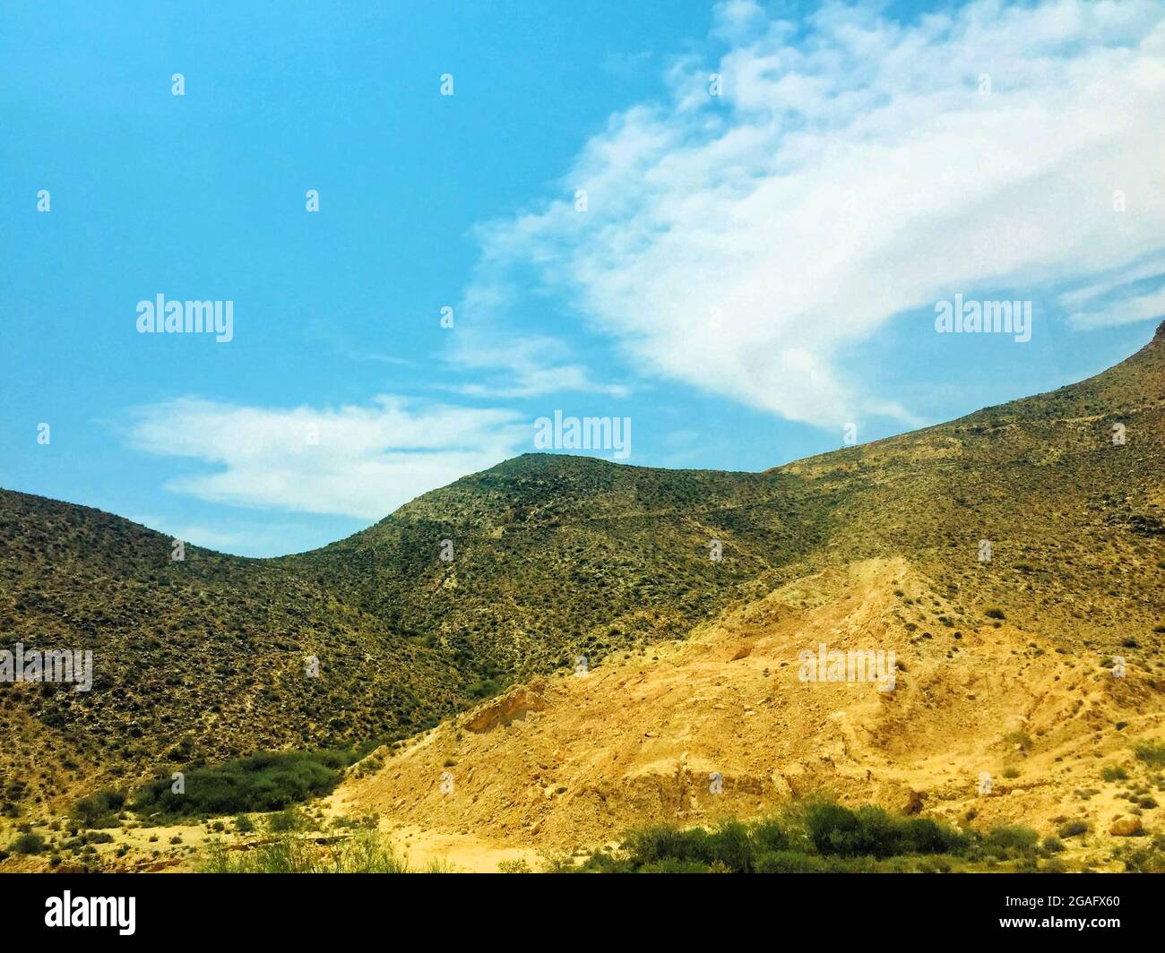 Stone mountains in the Sahara desert with blue sky and white clouds