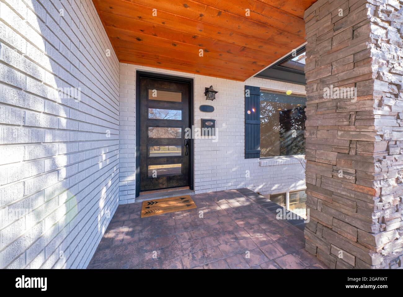 Entrance exterior of a house with white bricks and stone bricks column