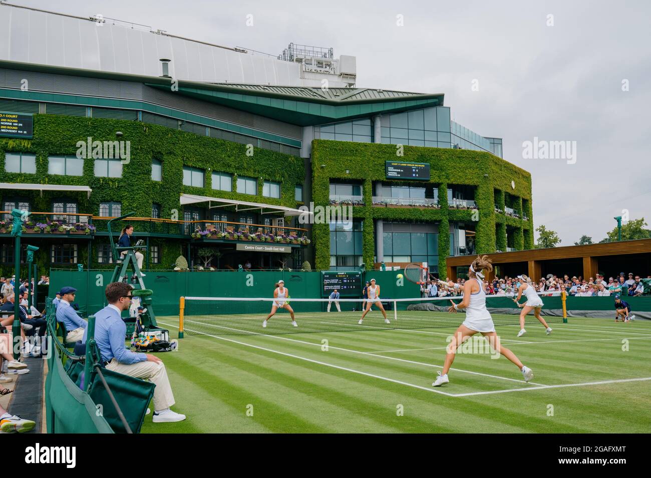 General views of A. Krunic and N. Stojanovic of Serbia takes on H. Carter of the USA and L. Stefani of Brazil at Wimbledon with Centre Court behind Stock Photo