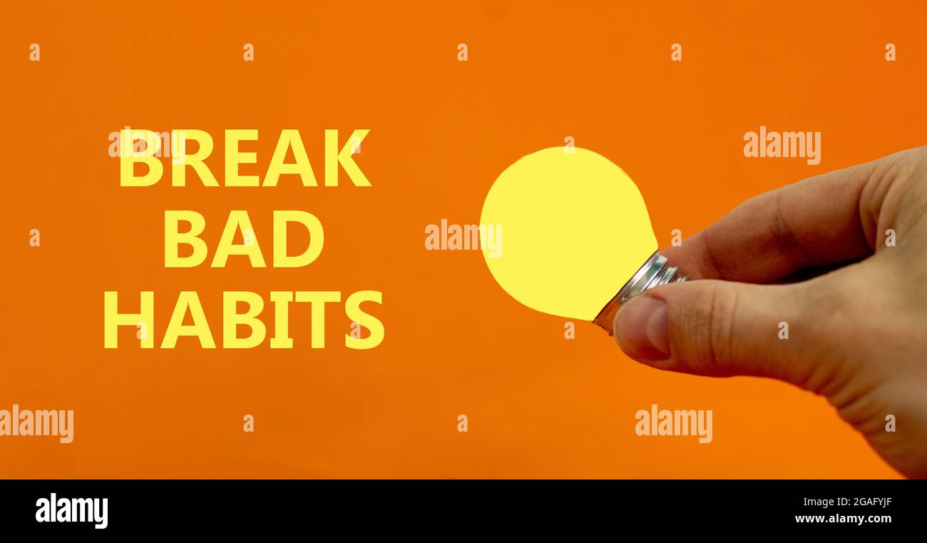 Break bad habits symbol. Businessman holds yellow shining light bulb