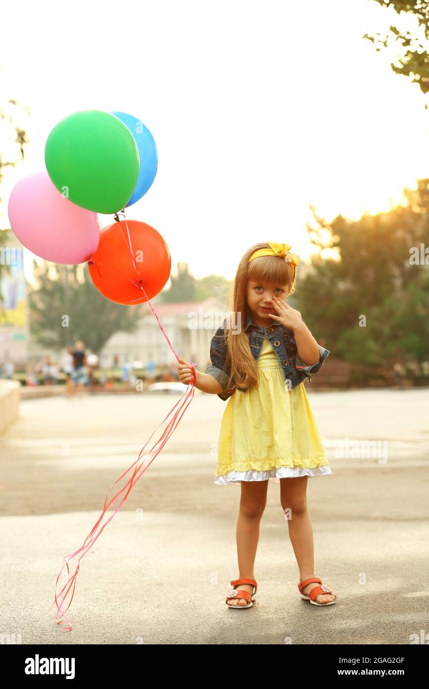 Little girl with balloons outside Stock Photo - Alamy
