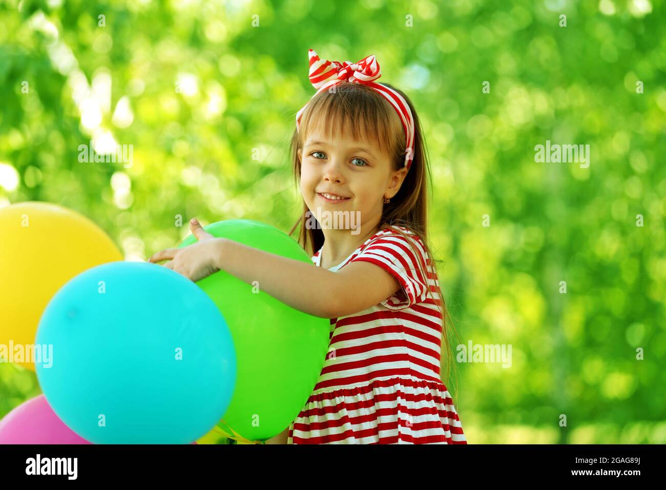 Little girl playing with balloons in the park Stock Photo - Alamy
