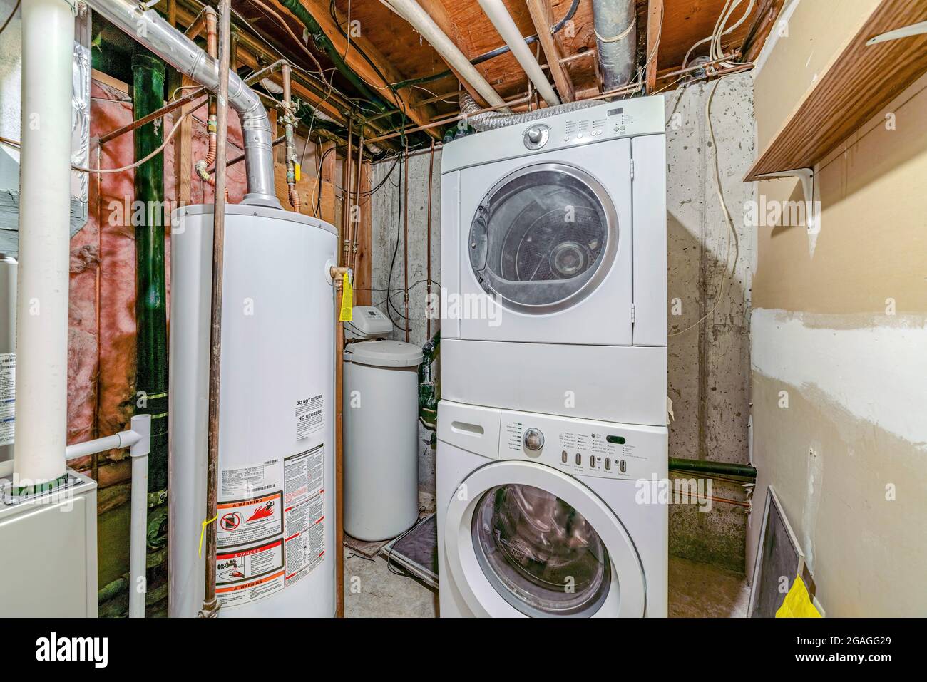 Basement interior with laundry appliances and water tank Stock Photo