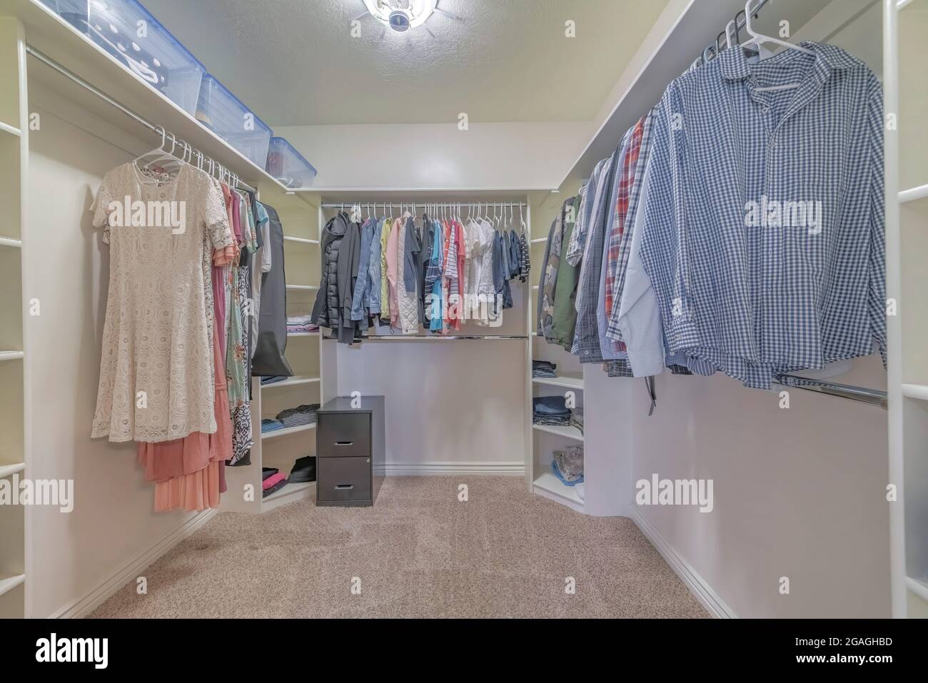 Interior of a walk in closet with shelving units and clothes Stock
