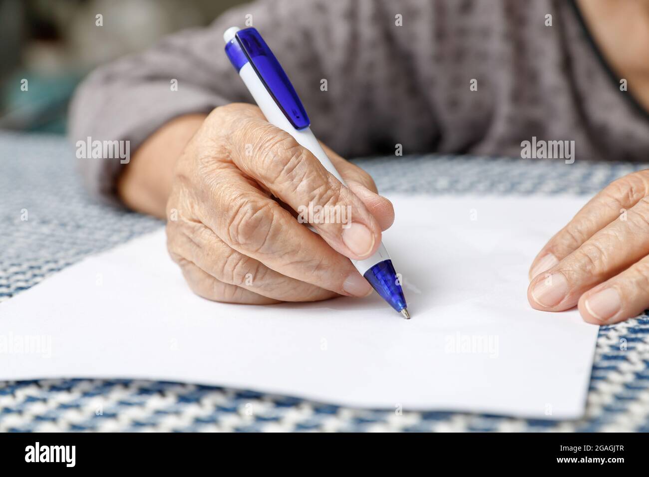 Elderly woman writing on blank paper stock photo alamy