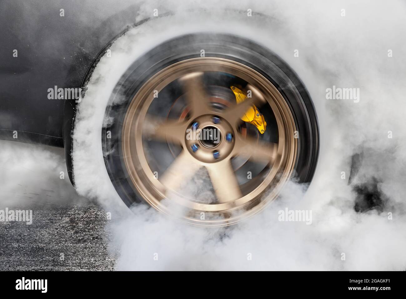 Drag racing car burns rubber off its tires in preparation for the race ...