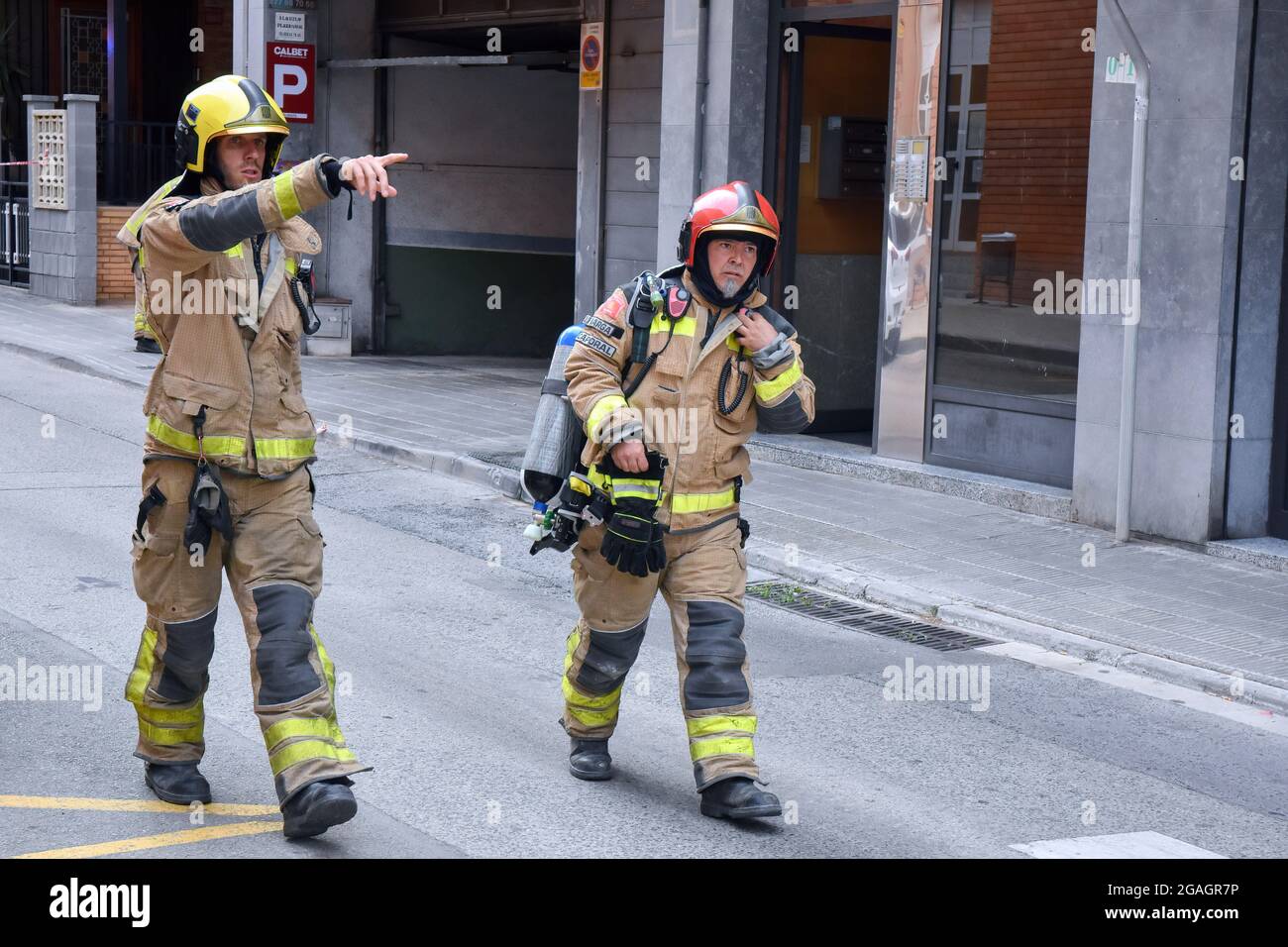 Two Catalonia firefighters seen during an inspection for a possible gas leak in Vendrell. A strong smell of gas alerted the residents of San Jordi Street, Vendrell where three teams of Catalonia Firefighters and several Local Police patrols attended closing access to the affected area. Firefighters with the help of technicians of the gas company began the gas measurements since the smell was coming from the underground sewer network and the presence of vapors or levels of propane, butane or natural gas was ruled out, hence a gas leak was ruled out and the possibility of a spill of some type of Stock Photo