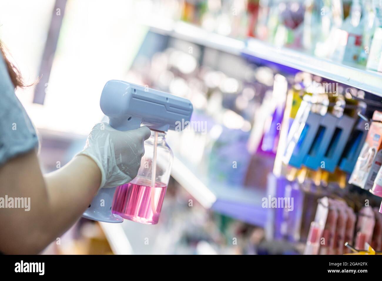 close up hand of staff wearing gloves using auto gun for spraying