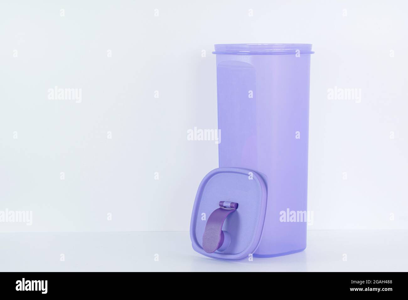 A large plastic purple water container with detached top cover on white background Stock Photo