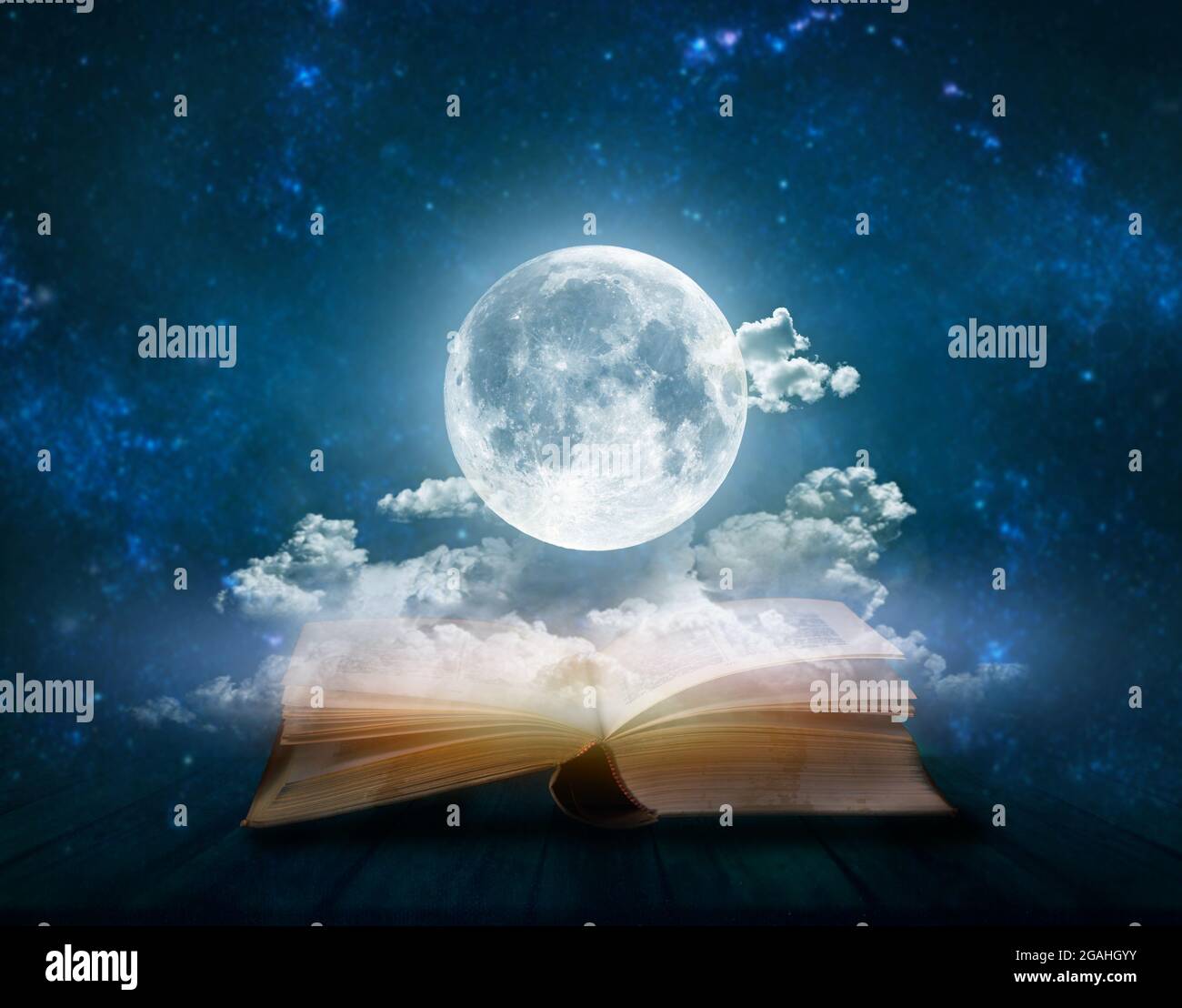 Full moon above open pages of old book; Astrology, zodiac, esoteric concept Stock Photo
