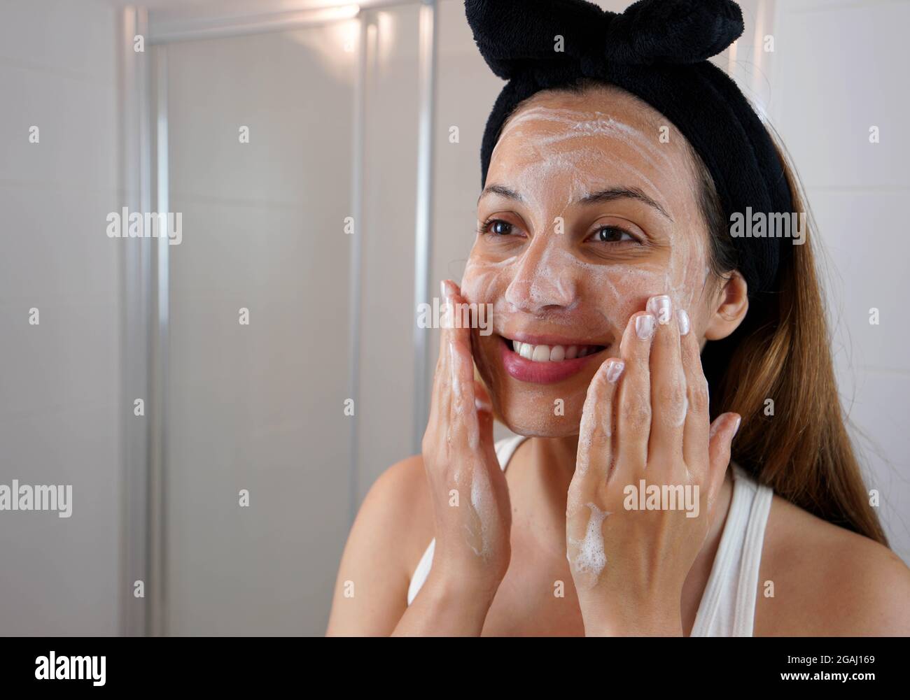 Young Skin Care Routine. Girl washing face foaming soap scrubbing skin