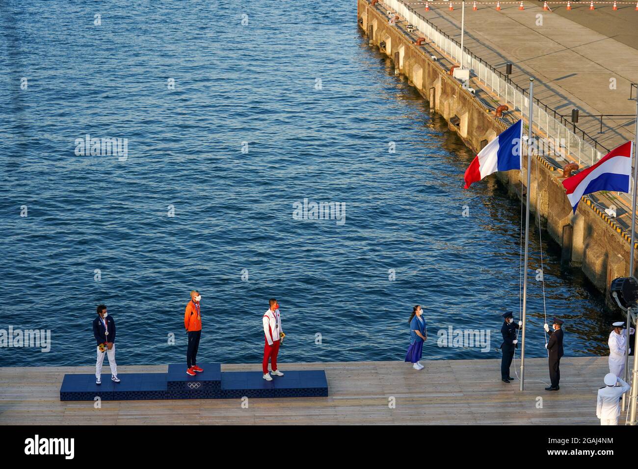 Tokyo, Japan. 31st July, 2021. TOKYO, JAPAN - JULY 31: Thomas Goyard of France winner of silver, Kiran Badloe of the Netherlands winner of gold and Kun Bi of China winner of bronze during the national anthem of the Netherlands during the Medal Ceremony of Sailing during the Tokyo 2020 Olympic Games at the Enoshima on July 31, 2021 in Tokyo, Japan (Photo by Ronald Hoogendoorn/Orange Pictures) Credit: Orange Pics BV/Alamy Live News Stock Photo
