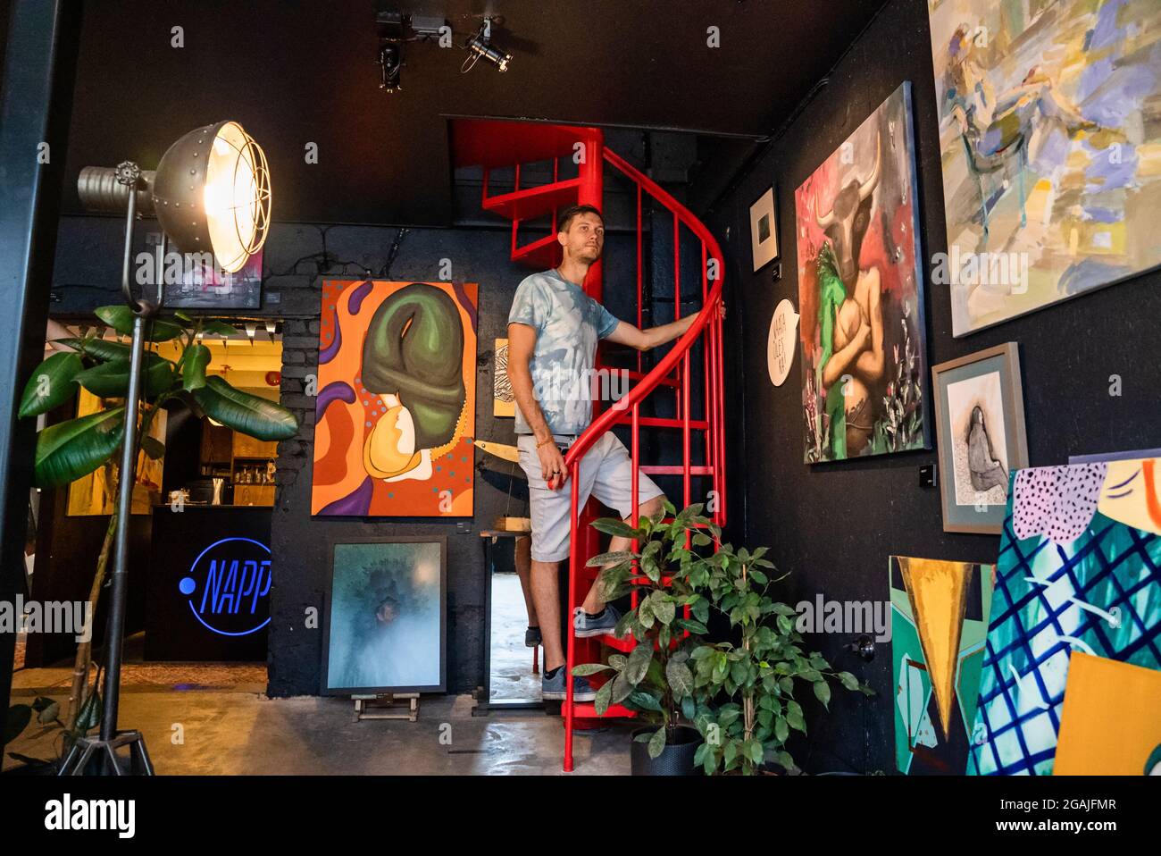 Young man exploring art gallery in a coffee shop. Stock Photo