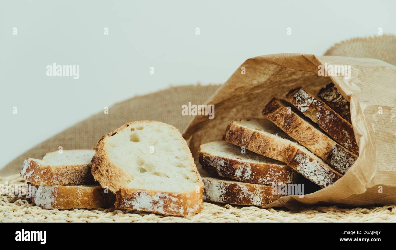 Sourdough bread with crispy crust cut into slices inside a paper bag ...