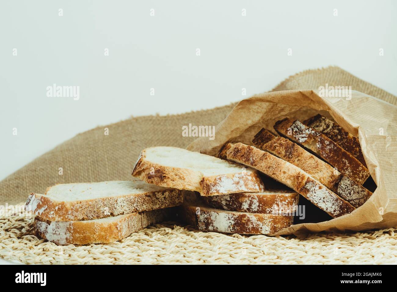 Sourdough bread with crispy crust cut into slices inside a paper bag ...