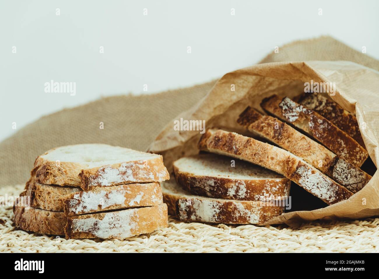Sourdough bread with crispy crust cut into slices inside a paper bag ...