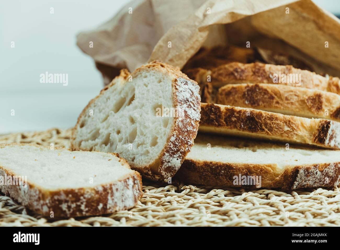 Sourdough bread with crispy crust cut into slices inside a paper bag ...