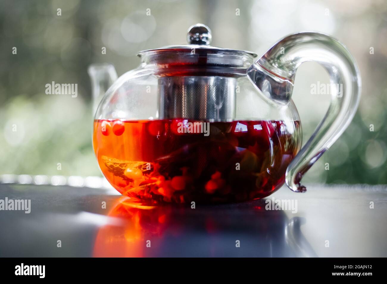 Glass teapot with hot red berry tea  , close-up Stock Photo