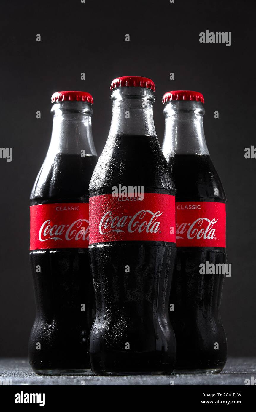 Lugansk, Ukraine - July 25, 2021: Coca Cola in glass bottles with water drops condensate on dark background. Creative minimal concept Stock Photo