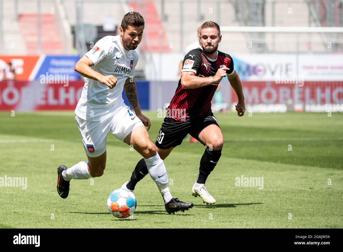 Ingolstadt, Germany. 31st July, 2021. Football: 2. Bundesliga, FC Ingolstadt 04 - 1. FC Heidenheim, Matchday 2 at Audi Sportpark. Marnon Busch of Heidenheim (l) and Marc Stendera of Ingolstadt in a duel for the ball. Credit: Matthias Balk/dpa - IMPORTANT NOTE: In accordance with the regulations of the DFL Deutsche Fußball Liga and/or the DFB Deutscher Fußball-Bund, it is prohibited to use or have used photographs taken in the stadium and/or of the match in the form of sequence pictures and/or video-like photo series./dpa/Alamy Live News Stock Photo