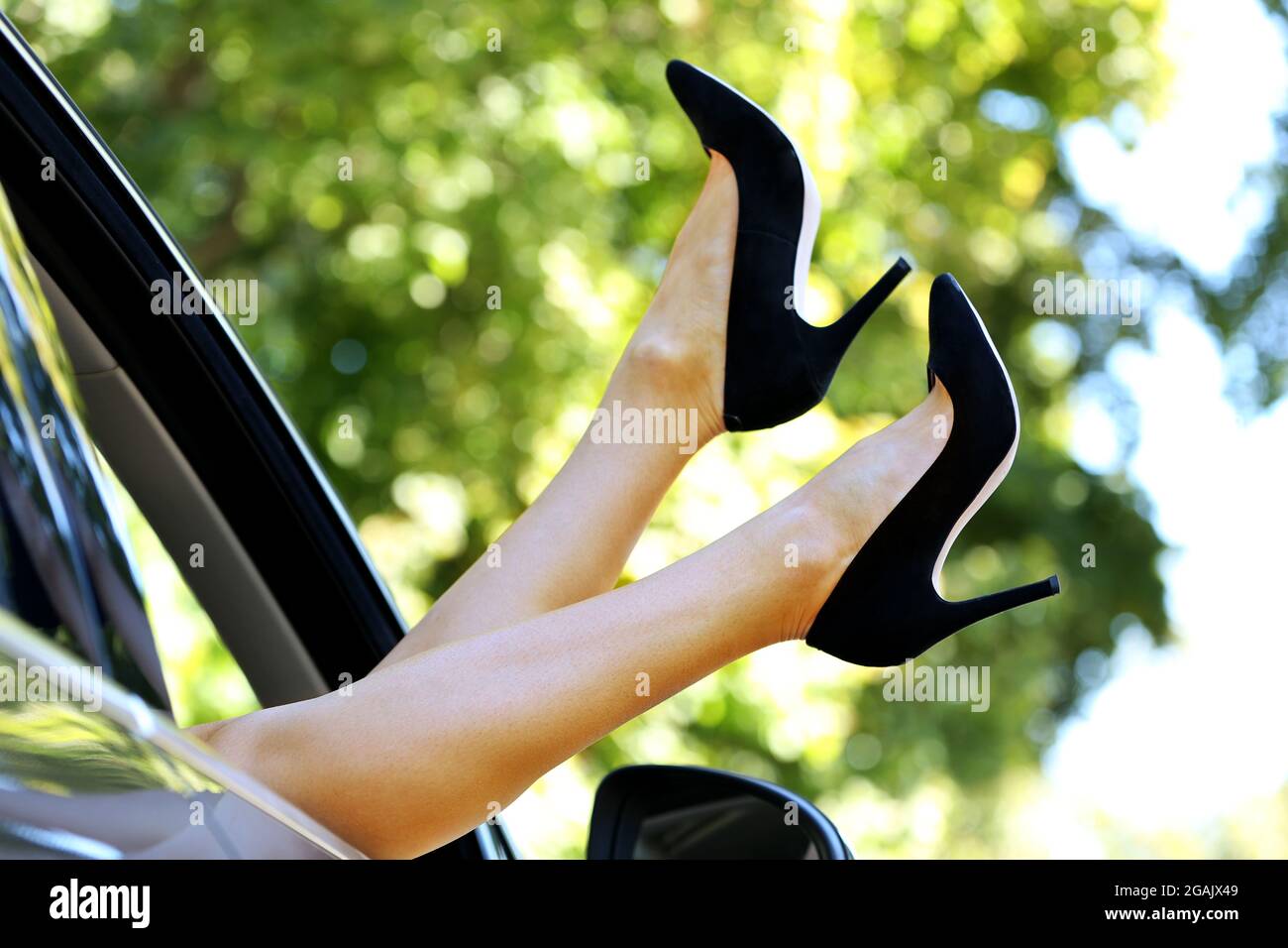 Woman's legs out of the car window Stock Photo - Alamy