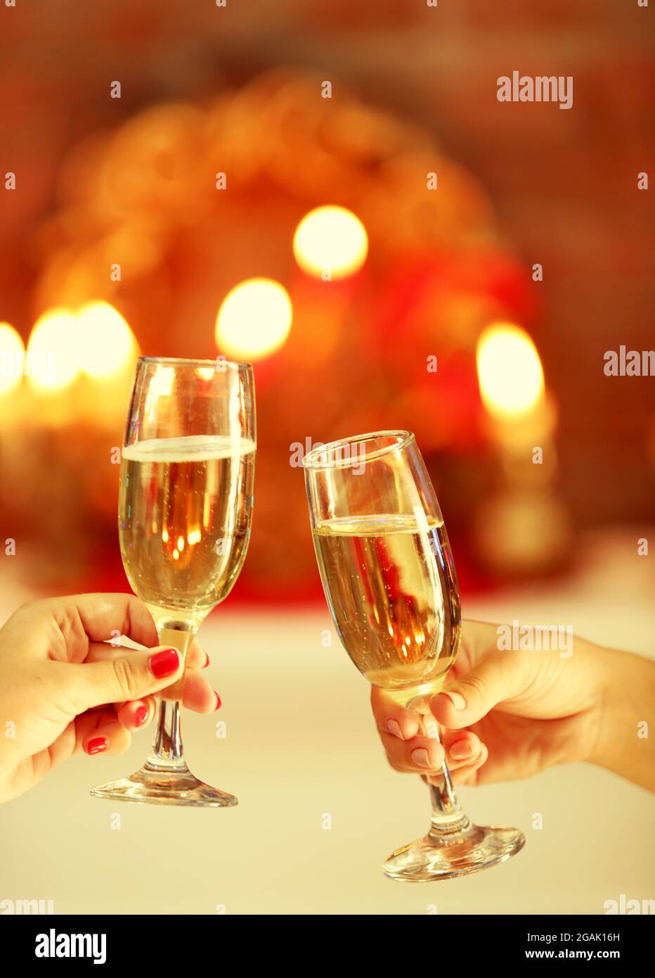 Clinking glasses of champagne in hands on bright lights background