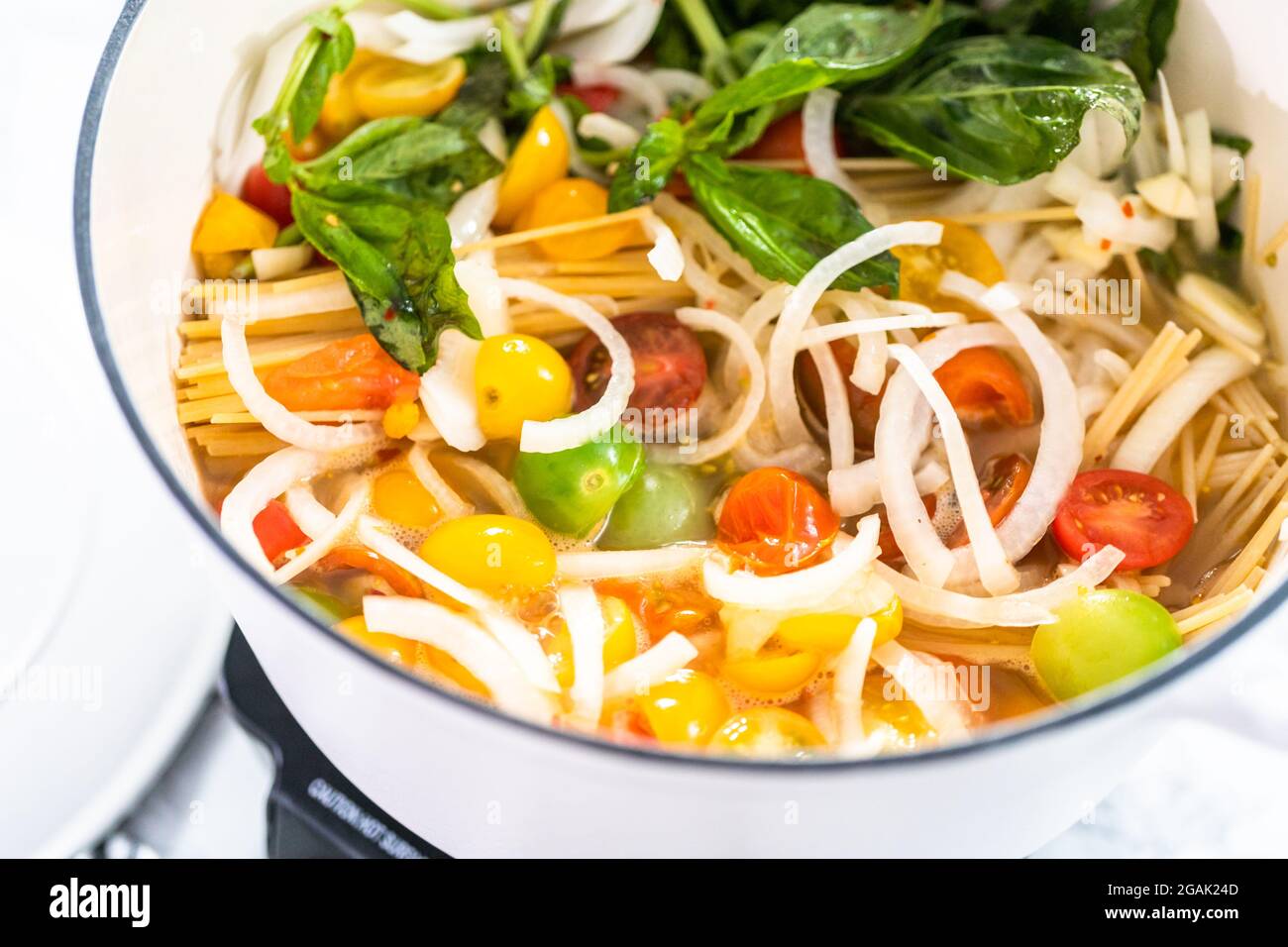 Preparing one pot pasta in enameled cast iron dutch oven Stock Photo Alamy