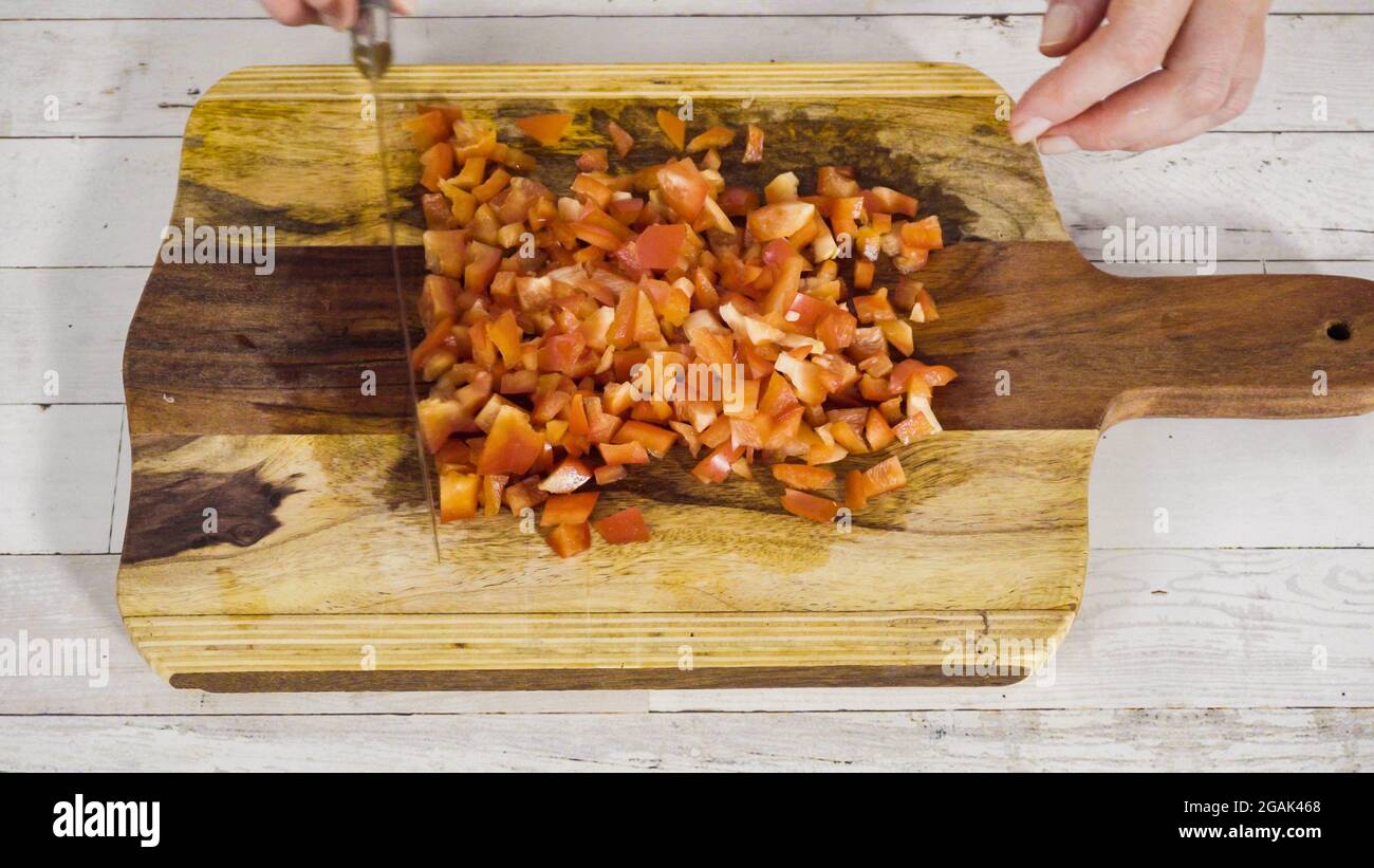 Mincing organic red bell peppers on a wood cutting board Stock Photo ...