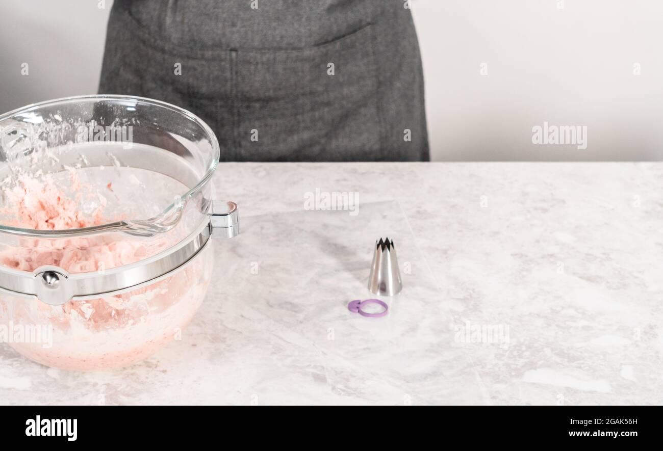 Whipping strawberry buttercream frosting in a standalone electric