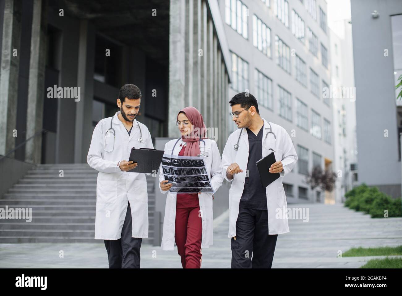 Three doctors, woman in hijab and two men in medical apparel