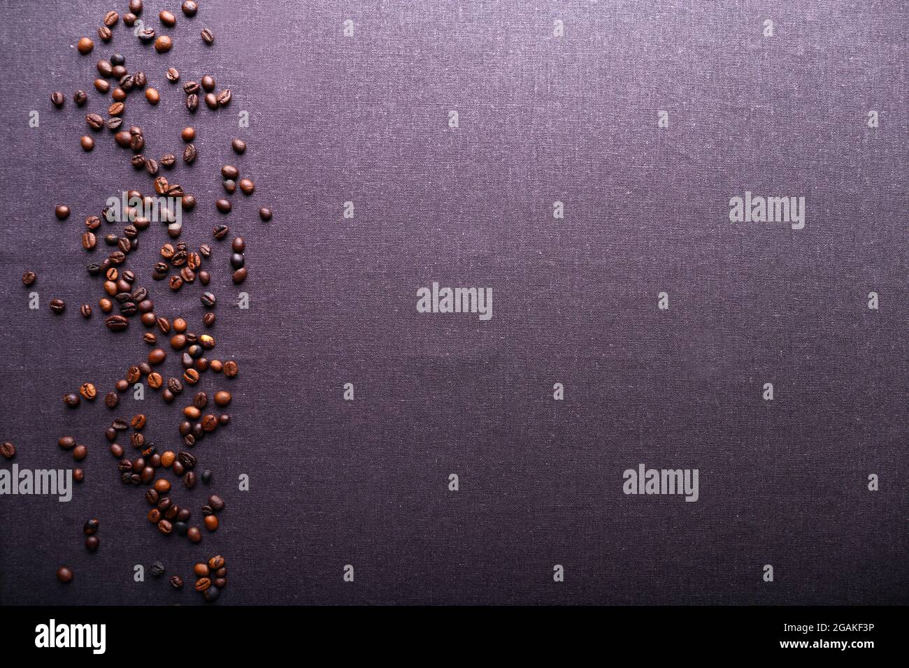 Roasted coffee beans on grey textile background Stock Photo - Alamy
