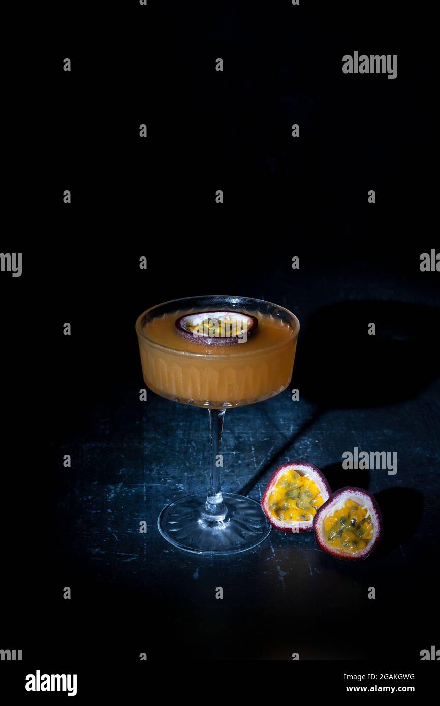 Passion fruit martini on dark background Stock Photo