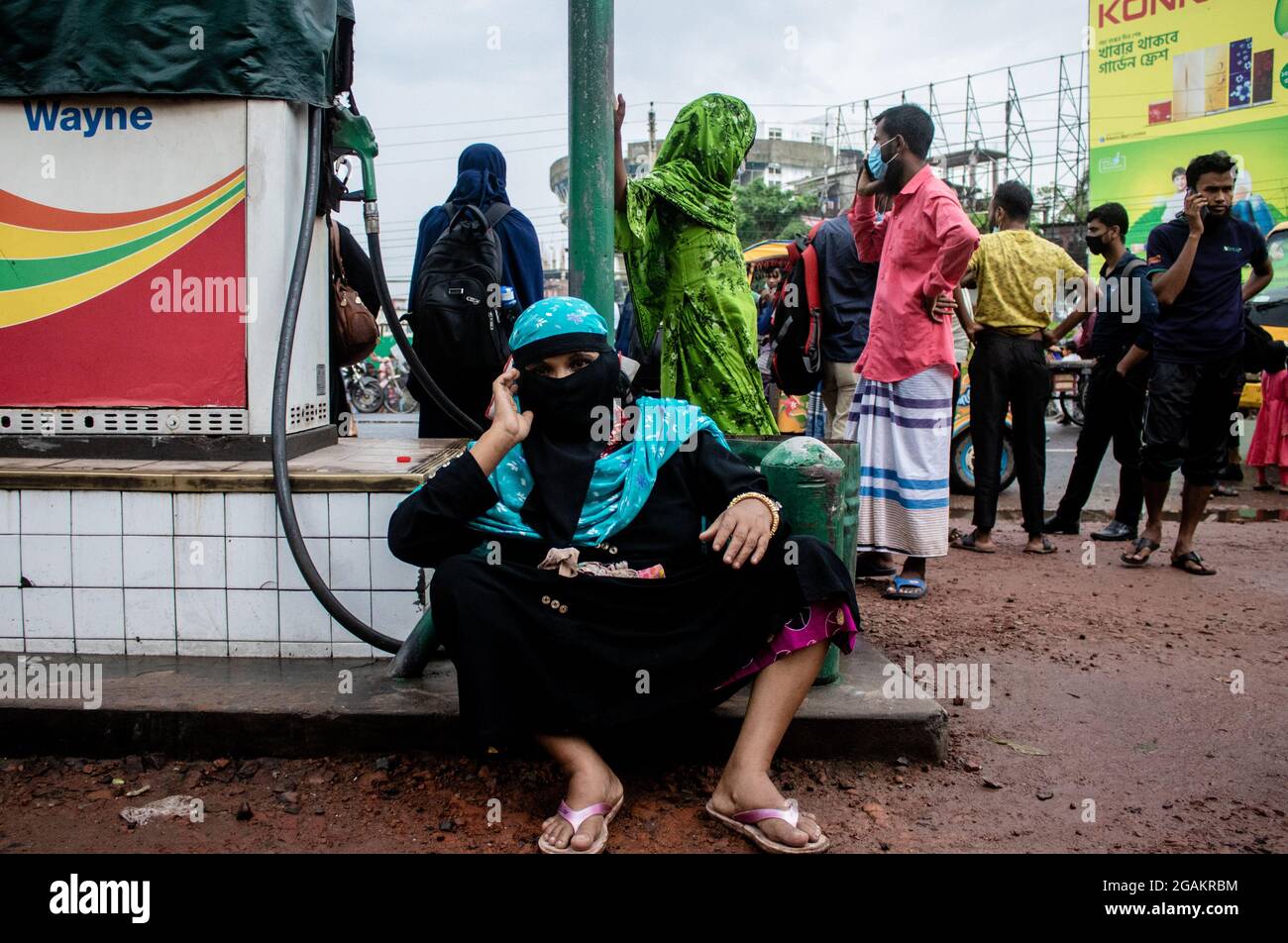 Barishal, Bangladesh. 31st July, 2021. A senior citizen seen sitting at the  oil pump premises as her son went to manage some sort of transportation so  that they can go back to