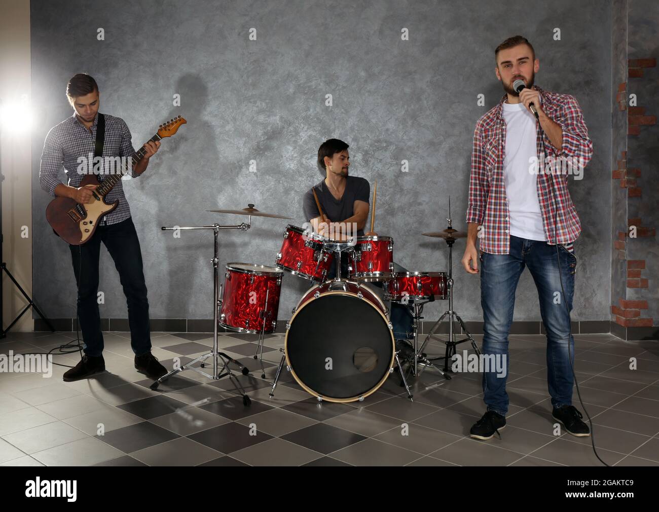 Musicians playing musical instruments and singing songs in a studio