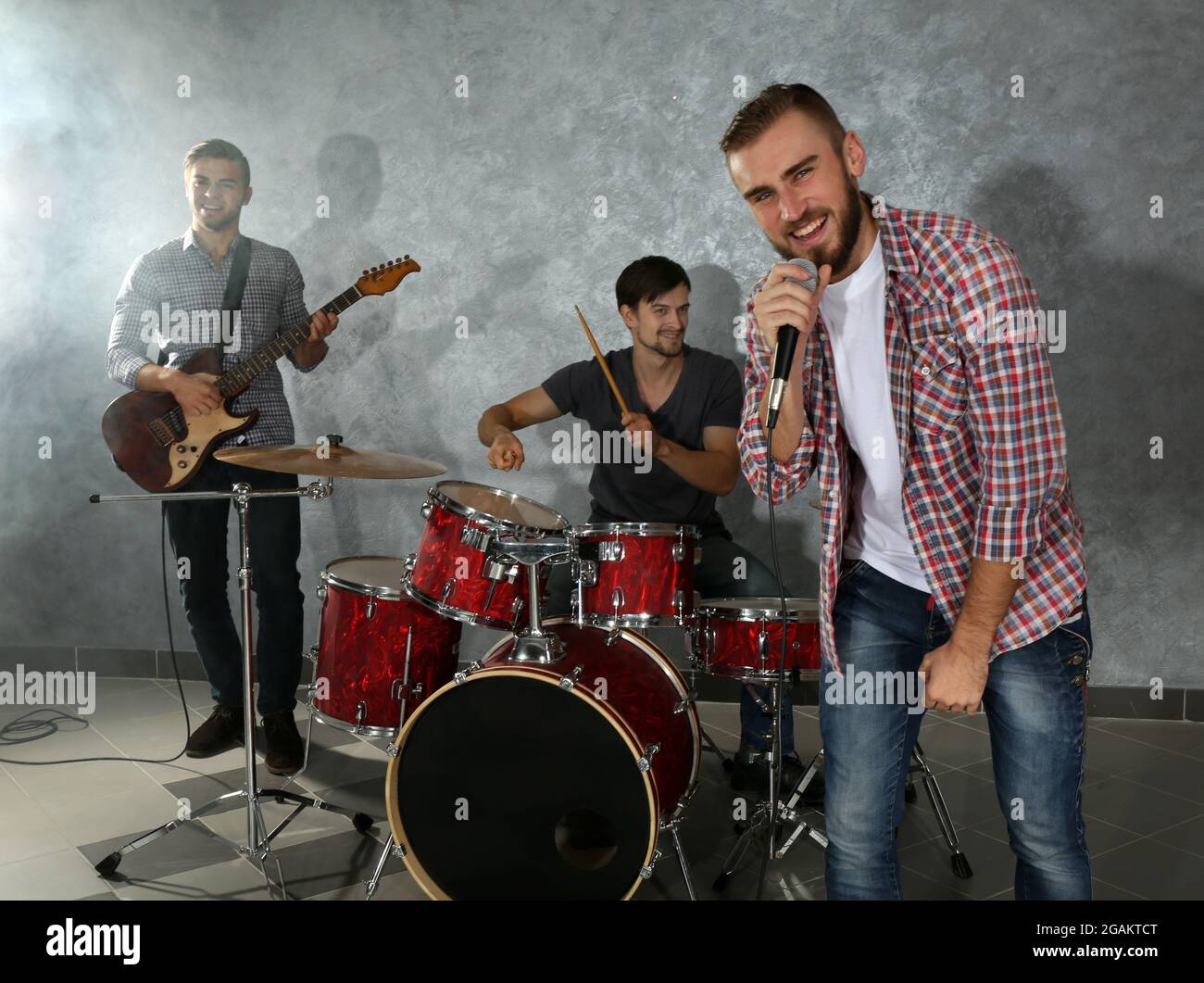 Musicians playing musical instruments and singing songs in a studio