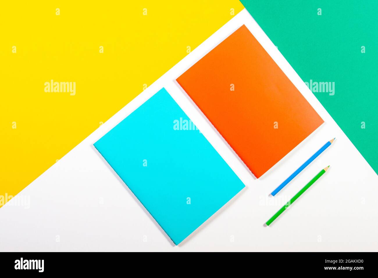 Colorful notebooks on green yellow white background Stock Photo - Alamy