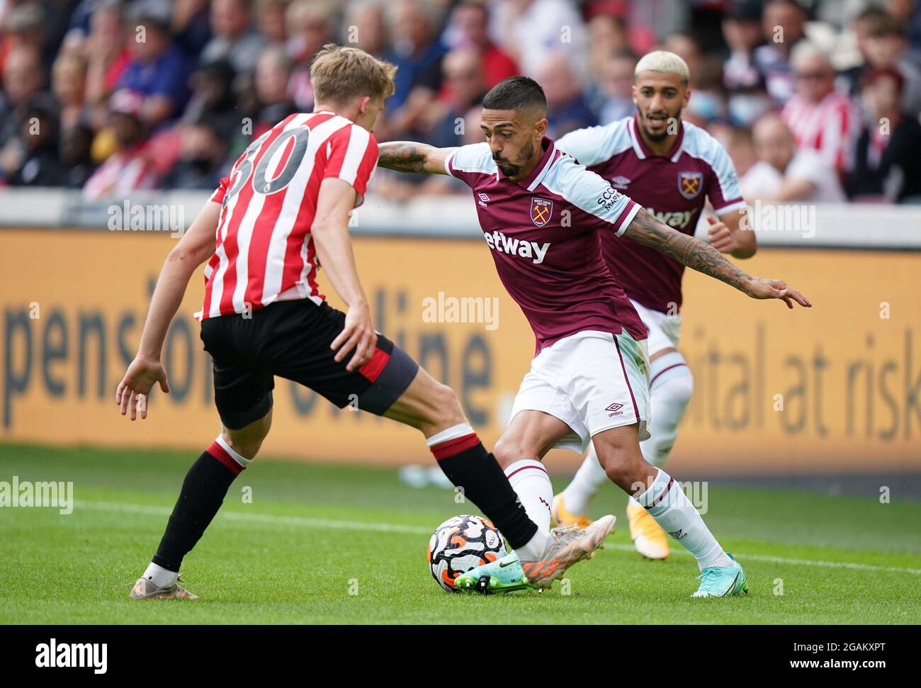 West Ham United's Manuel Lanzini (right) takes on Brentford's Mads Roerslev Rasmussen during the pre-season friendly match at the Brentford Community Stadium, London. Picture date: Saturday July 31, 2021. Stock Photo