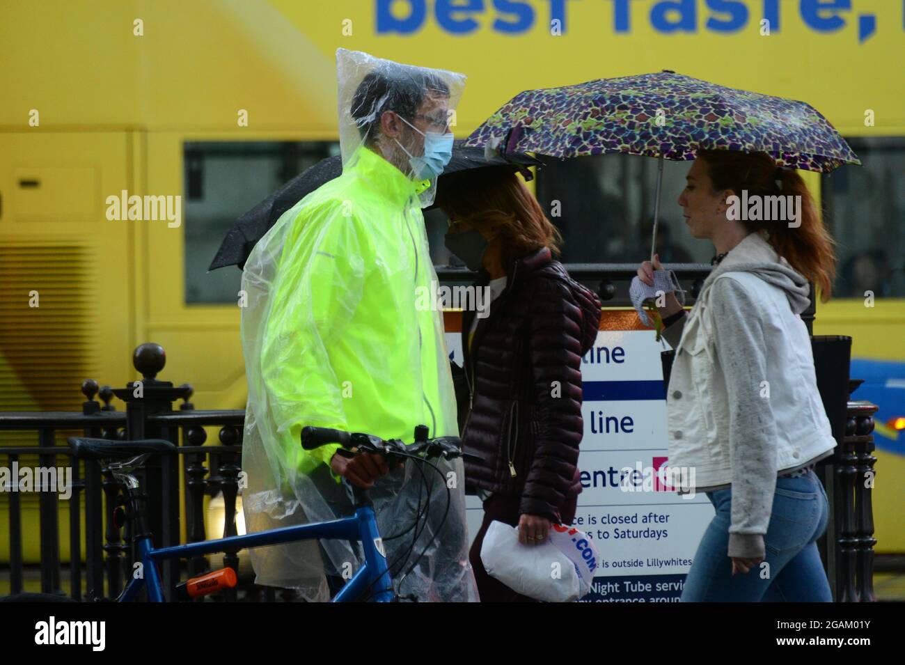 a man wears wet weather gear, in London’s downpour today Stock Photo
