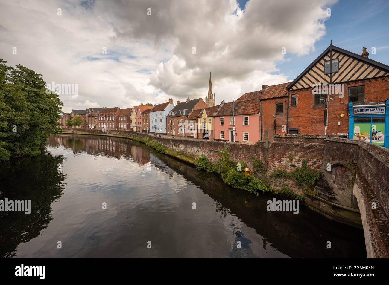 The River Wensum  in Norwich taken from Fye Bridge with houses and norwich cathedral in the background on a warm sunny day Stock Photo
