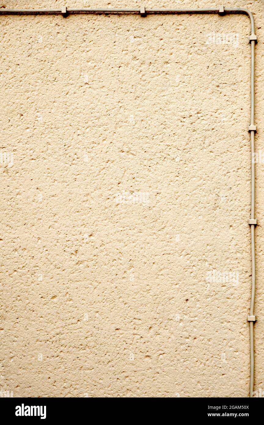Rough plastered wall, framed with electrical cable; grunge background with copy space Stock Photo