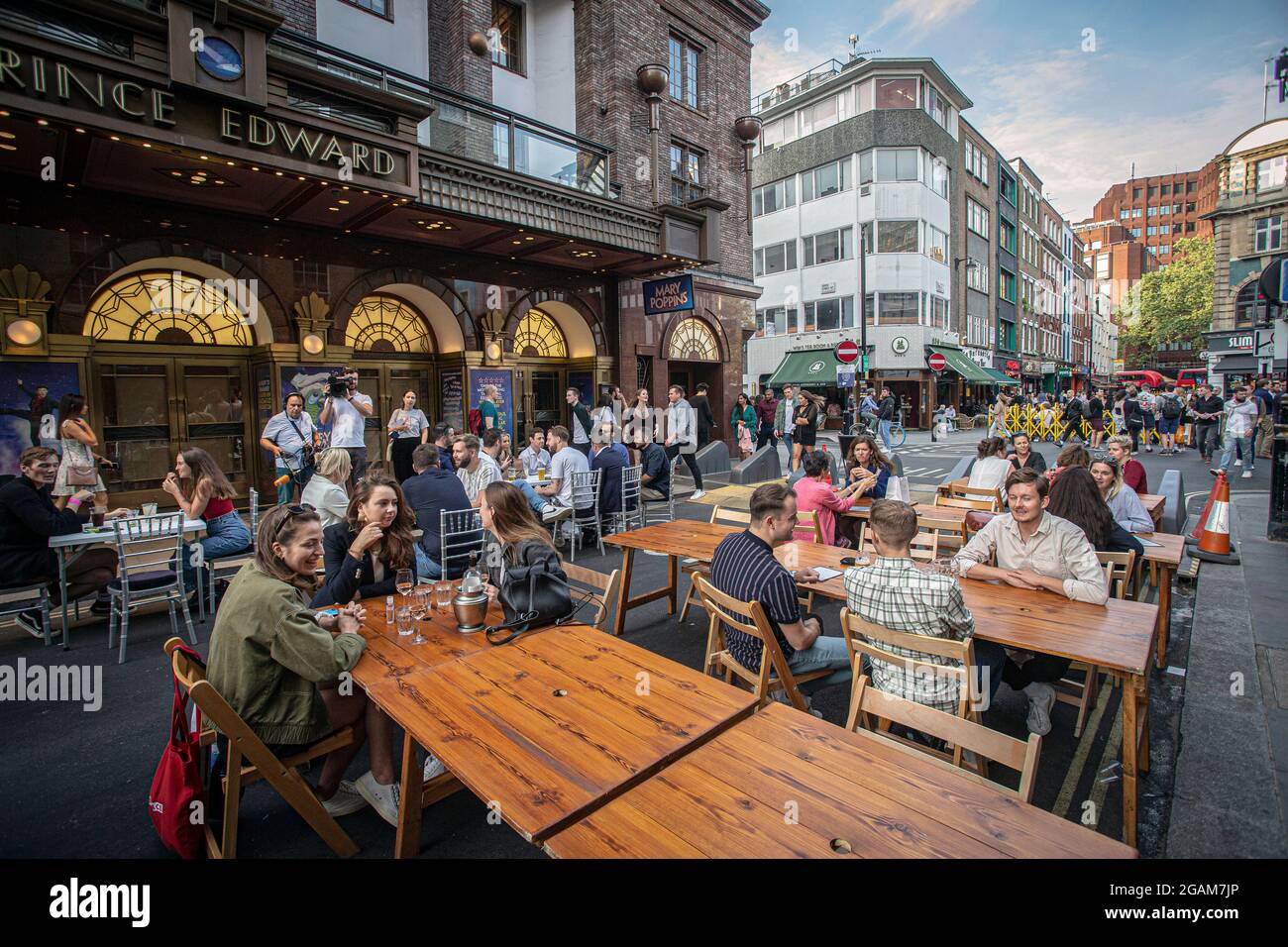 People drinking on tables placed outside on Old Compton Street in Soho, London,United Kingdom. Stock Photo