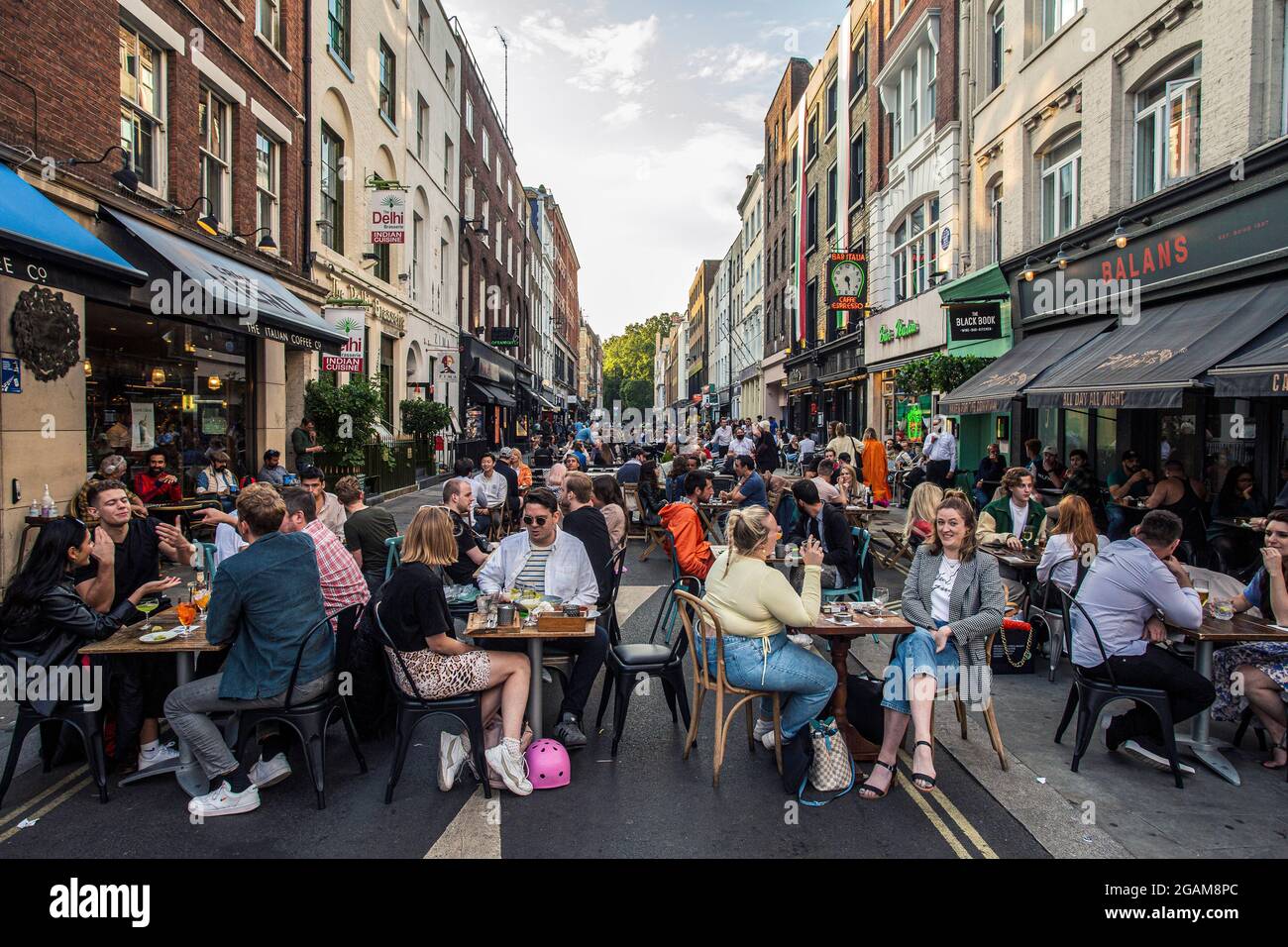 People eating on restaurant tables placed outside on Frith Street in Soho, London, UK Stock Photo