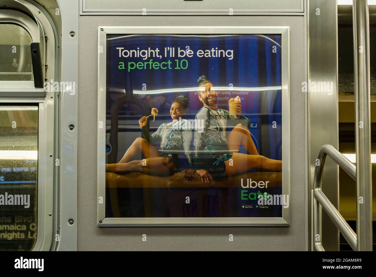 An advertisement for Uber Eats featuring gymnast Simone Biles, left, with amateur gymnast Jonathan Van Ness, in the subway in New York on Thursday, July 29, 2021. Uber Eats and the many other sponsors of Biles’ expressed their support for her after her decision to pull out of the individual, all-around gymnastics competition at the Tokyo Olympics.(© Richard B. Levine) Stock Photo