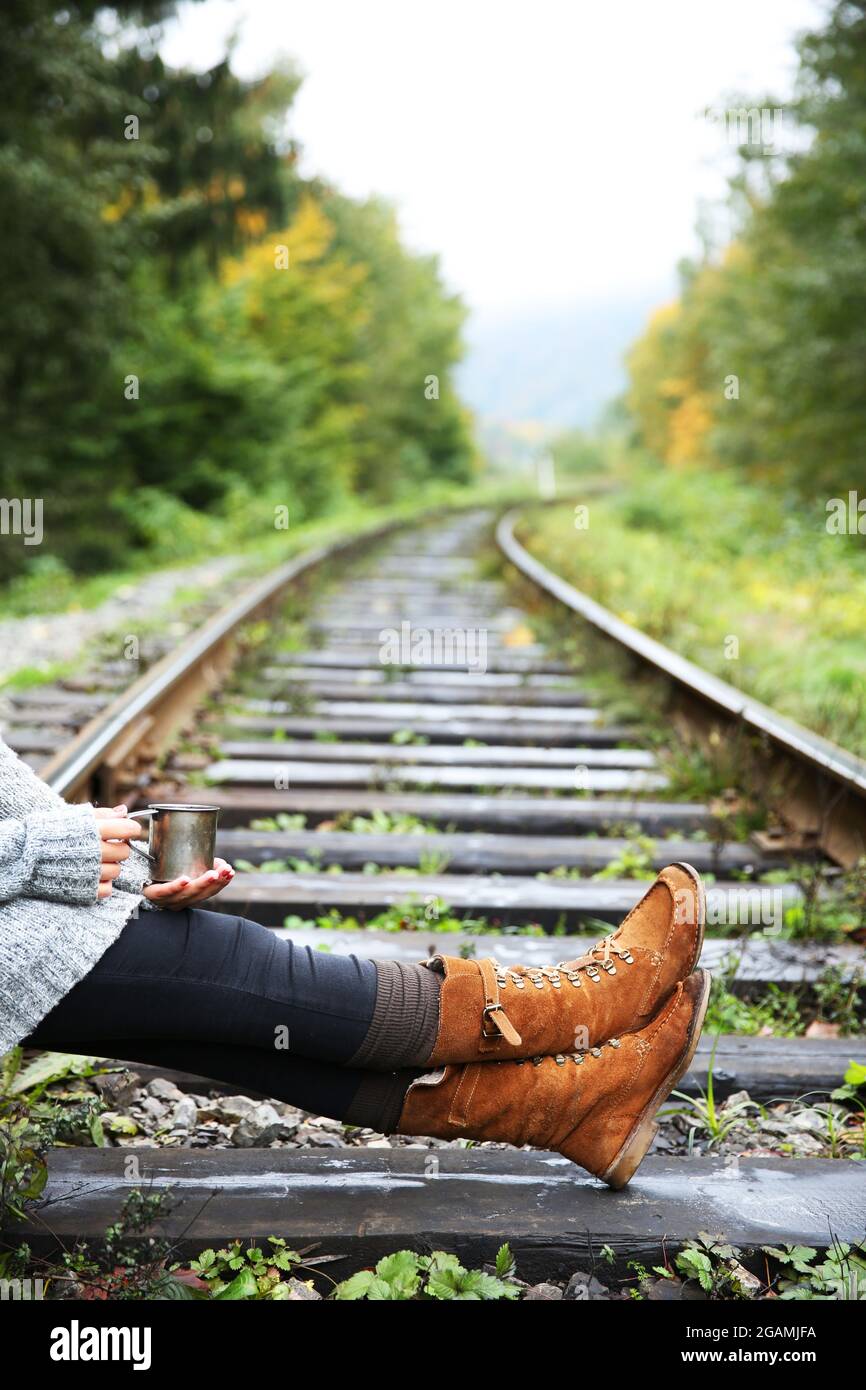 Young woman sitting on rail track Stock Photo