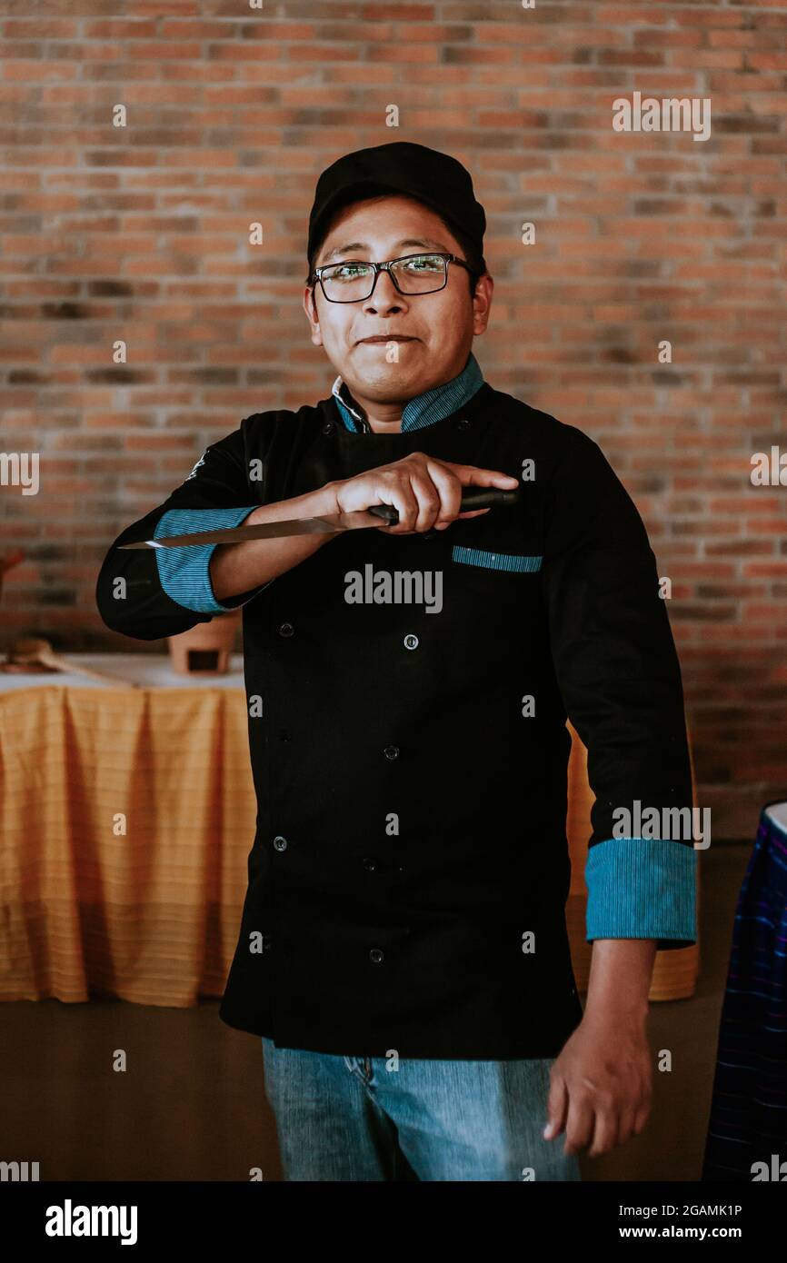 Young mexican cook holding a knife in mexican restaurant in Mexico