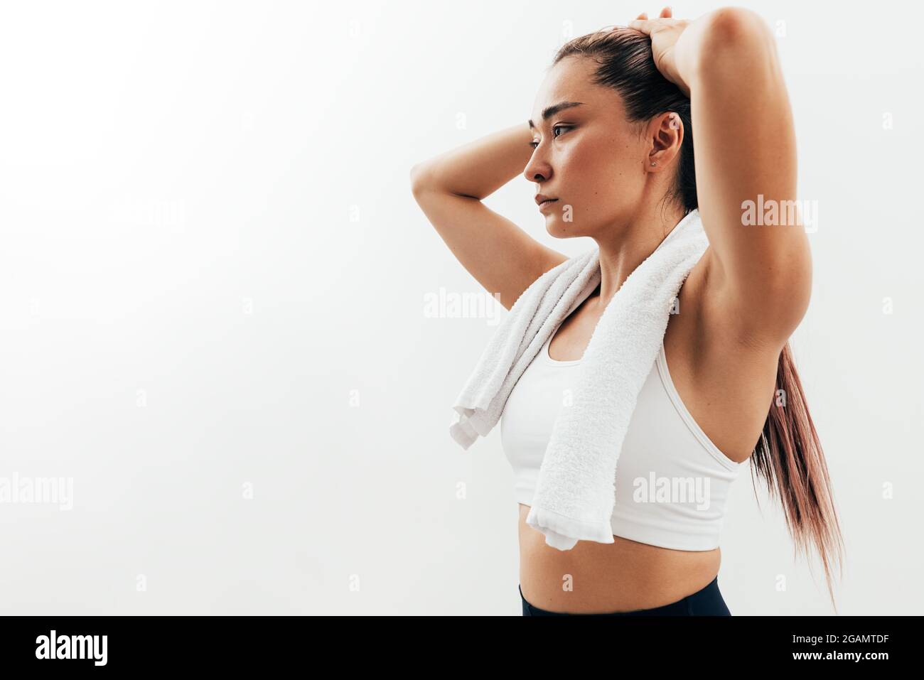Female Asian in sports attire with a towel over white background Stock  Photo