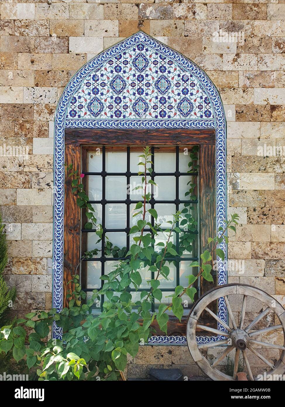 Window of an old building in Turkish style. The building is built of stone. The framing is made of painted tiles. Stock Photo