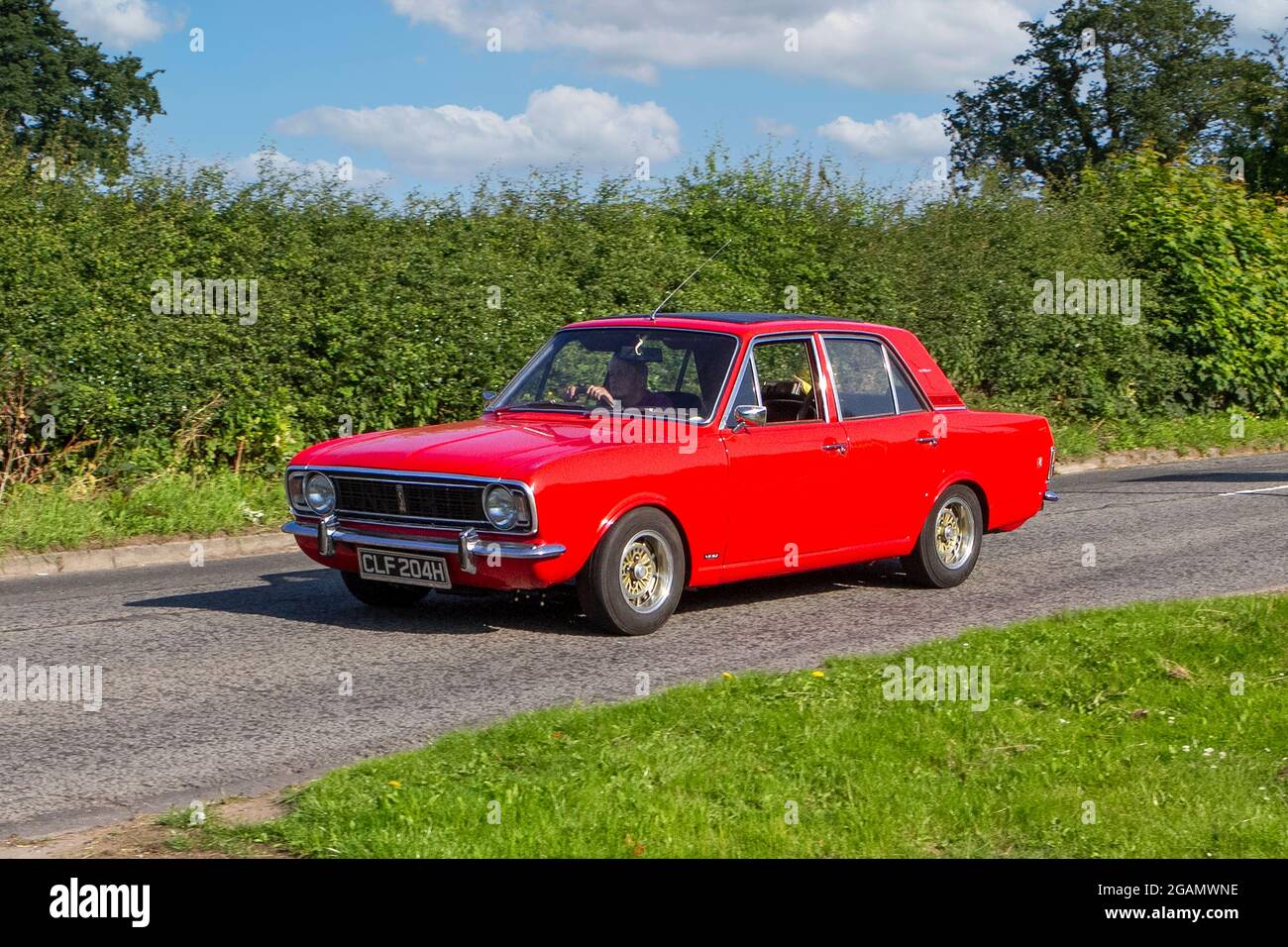 A 1970 70s Ford Cortina Red Car classic vintage car arriving at the Capesthorne Hall classic car show. Stock Photo