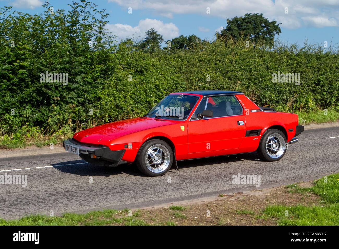 A 1983 80s Fiat X1/9 Red Petrol classic vintage car arriving at the Capesthorne Hall classic car show. Stock Photo